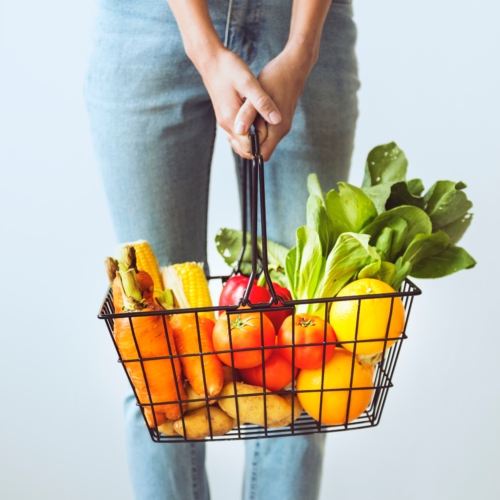 a girl holding a basket of fruit