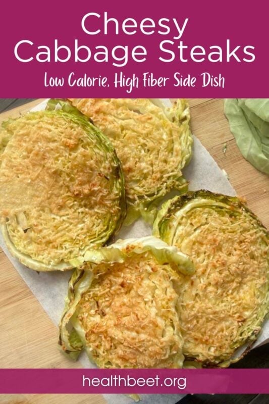 four cheesy cabbage steaks on white parchment paper on a wood cutting board