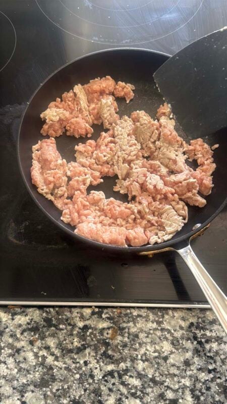 ground chicken cooking in a pan on a stovetop