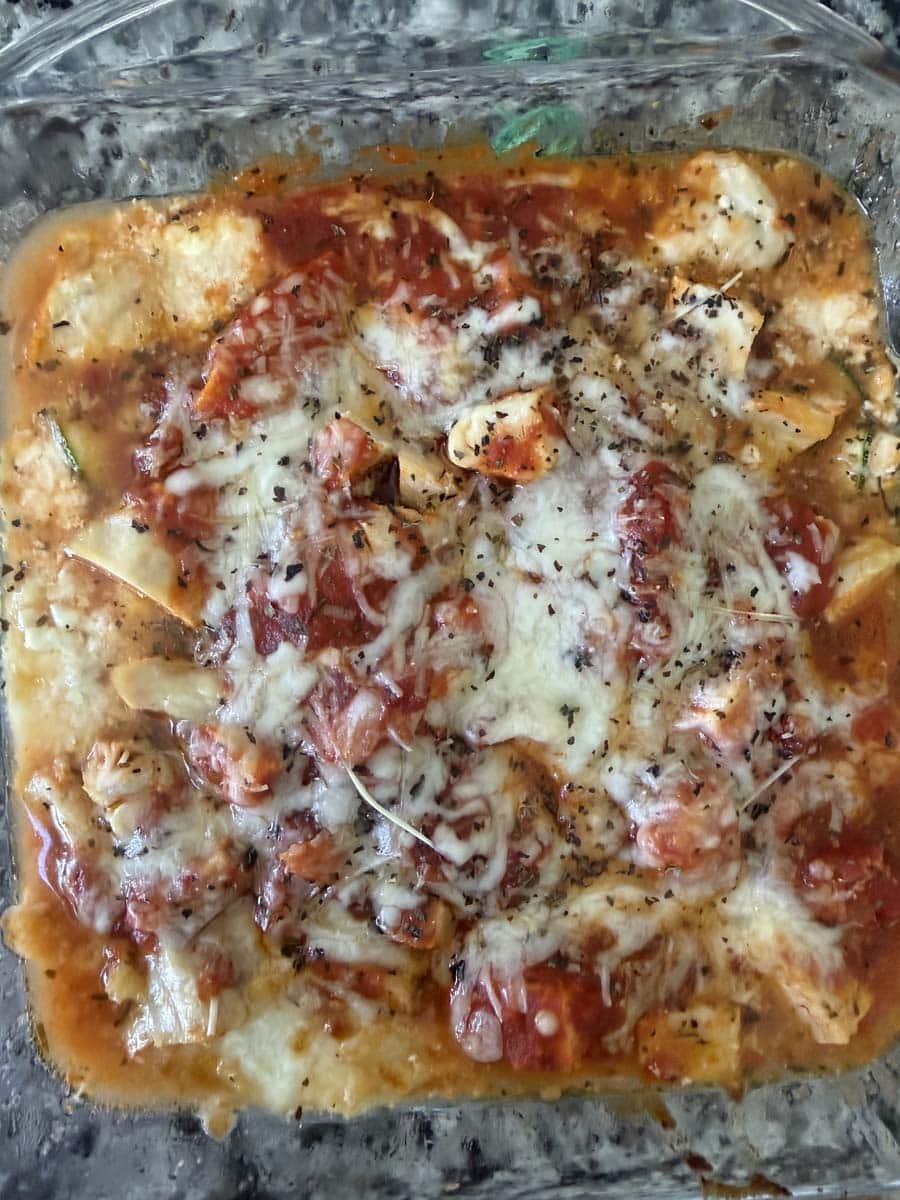 close up of a chicken parmesan protein recipe in a clear glass dish