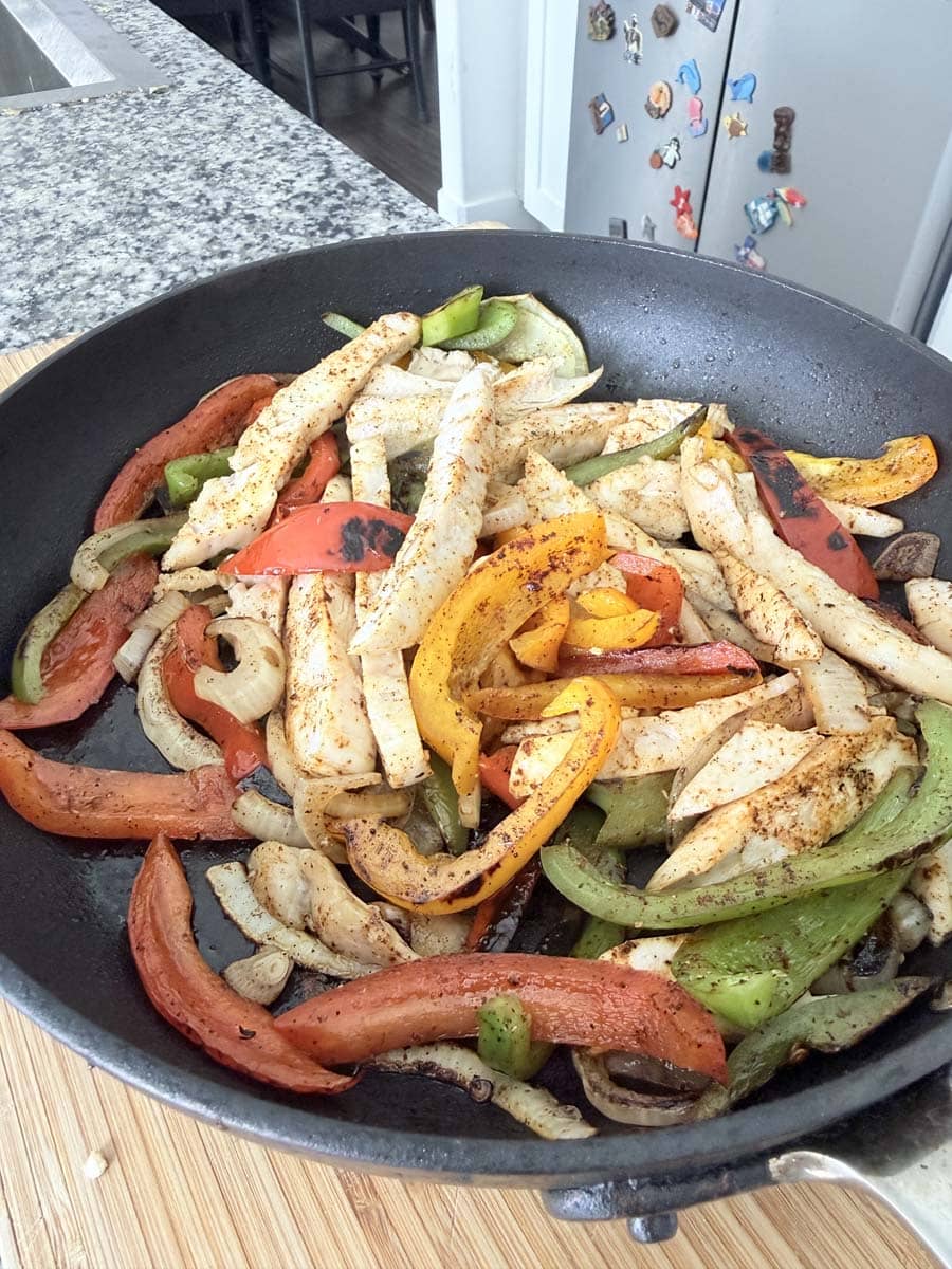 chicken, peppers, and onions in a skillet