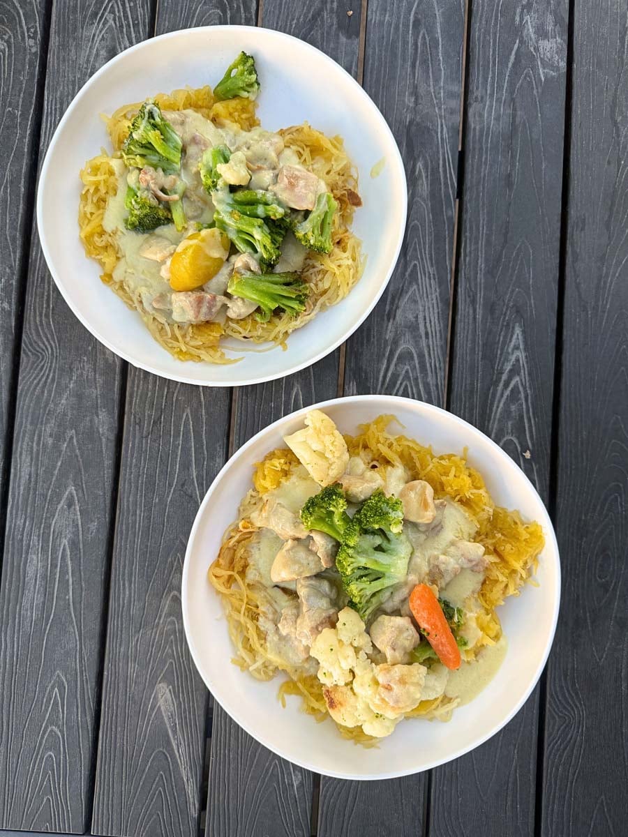 overhead view of two white plates filled with chicken alfredo spaghetti squash