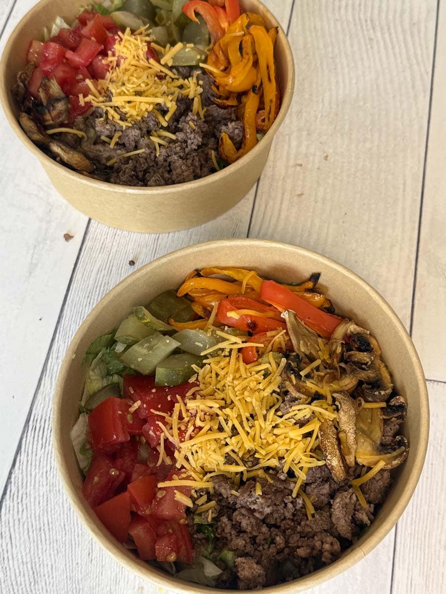 overhead view of two cheeseburger bowls in brown bowls
