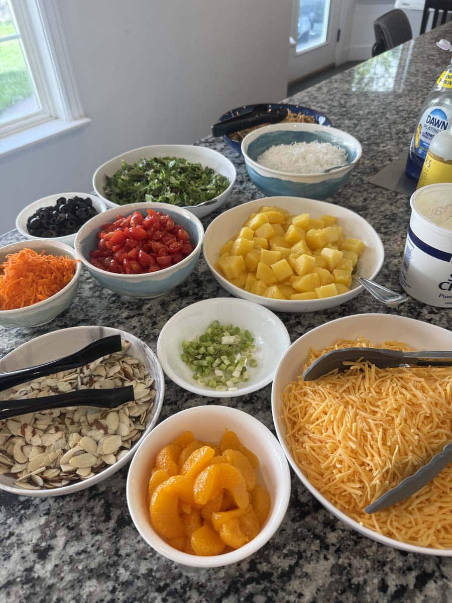 bowls of ingredients and toppings for hawaiian haystacks on a kitchen countertop